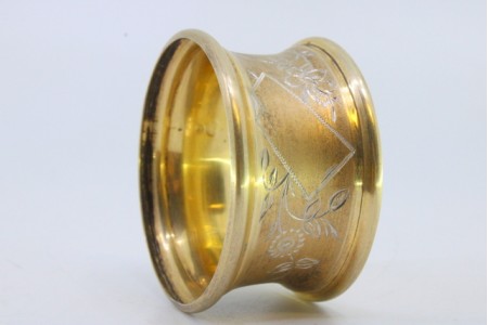 Argola de guardanapo em prata dourada com motivos florais gravados envolvendo cartela para monograma.